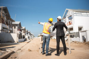 Vue centrée sur deux professionnels de la rénovation appartement, étudiant les stratégies parfaites pour rentabiliser l'appartement