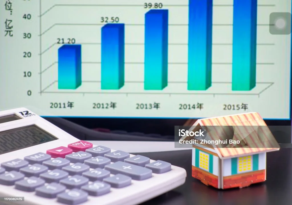 Un concept financier lié à l'immobilier avec une calculatrice, une maquette de maison et un graphique représentant une progression de données sur plusieurs années. Cela fait allusion au calcul de l'amortissement LMNP.