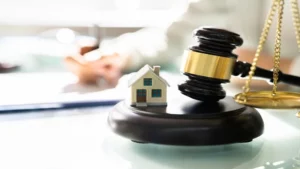 Une illustration symbolisant les aspects juridiques et fiscaux de l'immobilier, avec un marteau de justice et une maison miniature.