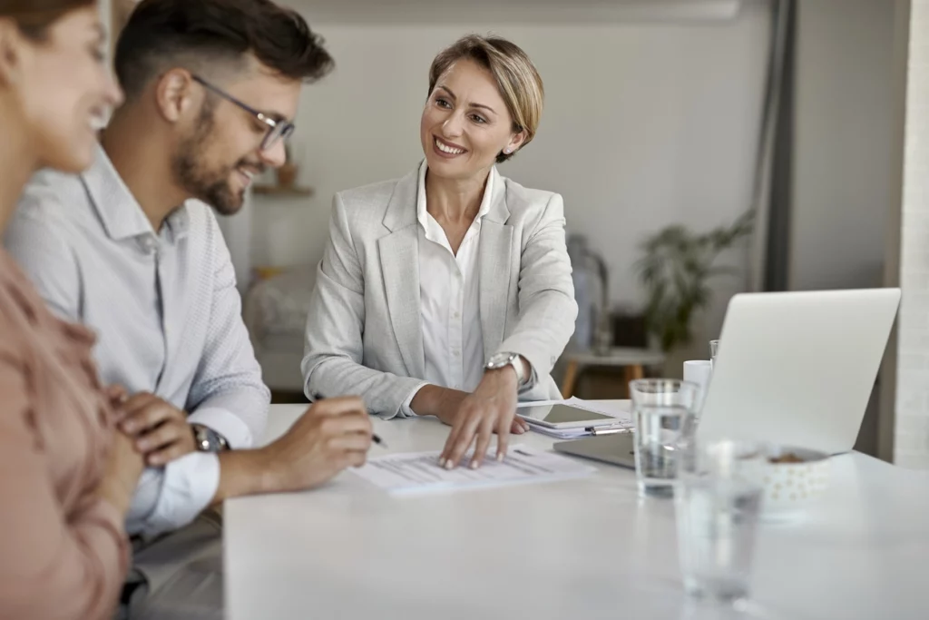 Image d'un gestionnaire de patrimoine conseillant un couple d'investisseur sur la façon dont ils peuvent réduire leurs impôts