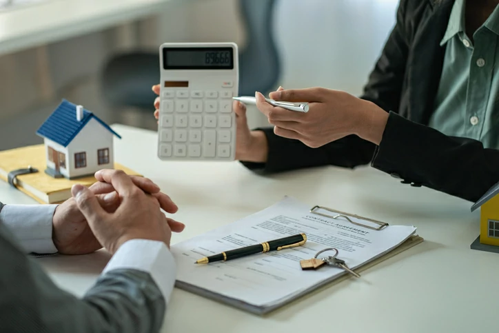 prêt différé : personne tenant une calculatrice devant une autre personne