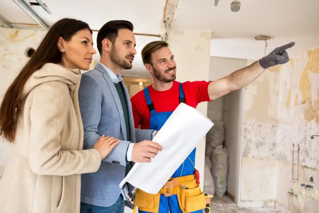 Image montrant un couple qui se fait accompagné par un professionnel RGE dans le montage de dossier pour obtenir une aide pour la rénovation logement locatif.