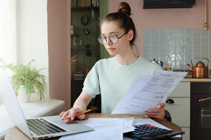 reduction impot logeemnt etudiant : une étudiante consultant des documents sur son bureau