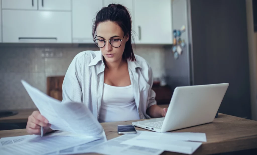 déclaration location meublée : une femme consulte document et formulaire de déclaration