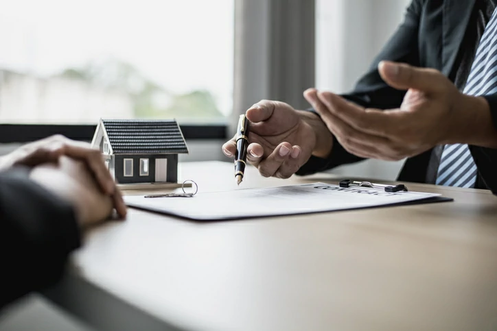 caution pret immobilier : un créancier explique les conditions d'emprunt à un client pour un projet immobilier.