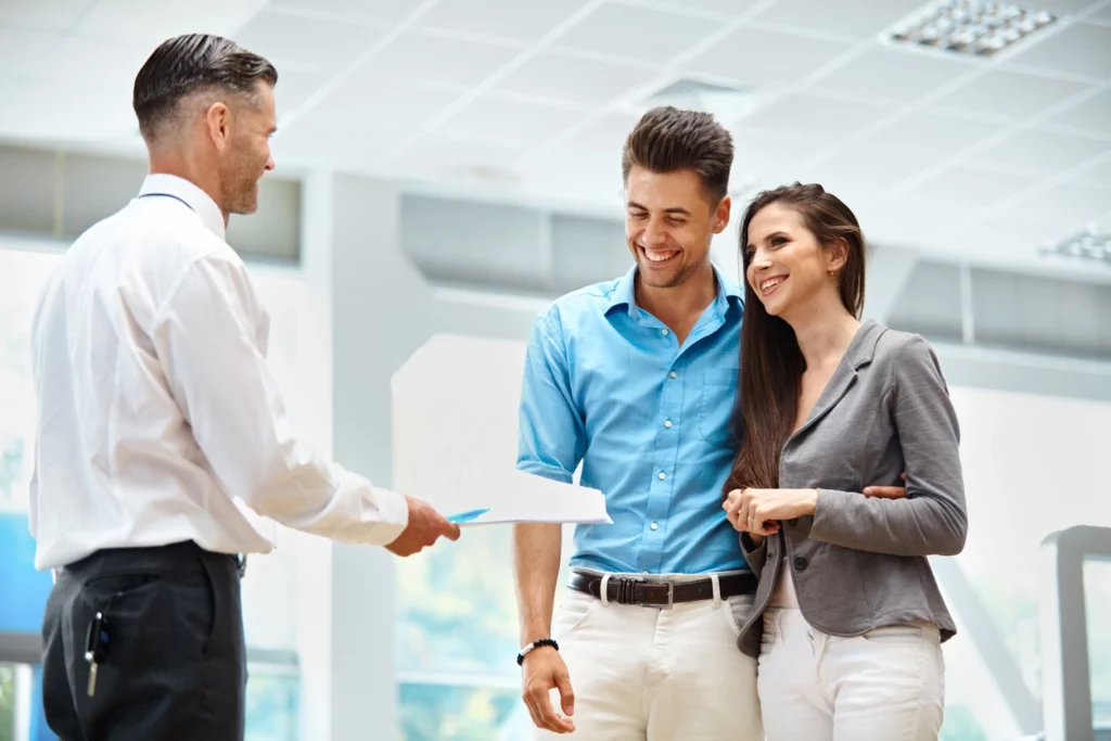 Image d'un couple accompagné par un expert immobilier et qui les conseille sur les avantages fiscaux d'une SCI à l'IR en cas de transmission et de succession patrimoniale