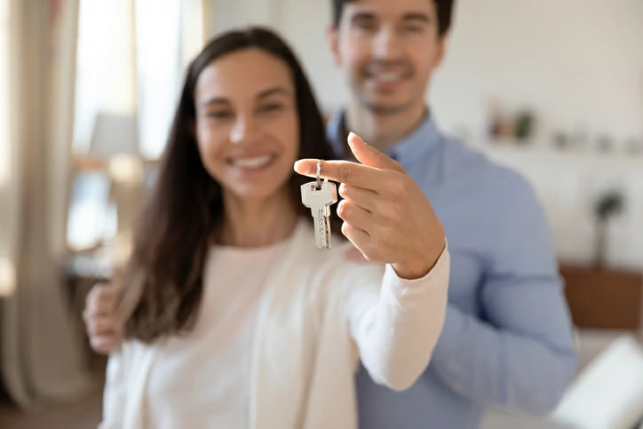 démembrement croise : couple souriant tenant une clé